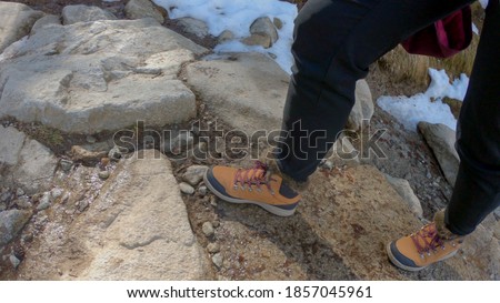 Woman hiking in snow. Boots and legs detail. Outdoor activity, winter walk at the heart of the ski station of Pont d’Espagne, Pyrenees National Park, Hautes-Pyrénées department, Occitanie, France.