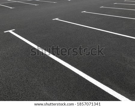 Parking lot markings, black and white stripes on bitumen. Empty parking place at store. Marking road lines in parking lot.