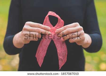Woman hands holding pink ribbon, breast cancer awareness, World cancer day concept
