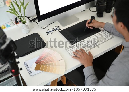 Cropped shot of a male graphic designer working with interactive pen display, digital drawing tablet and pen on a computer in workstation.