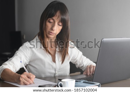 Woman with white shirt works with laptop