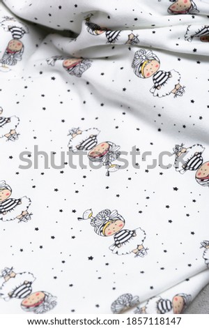 White fabric with a children's pattern on a light background