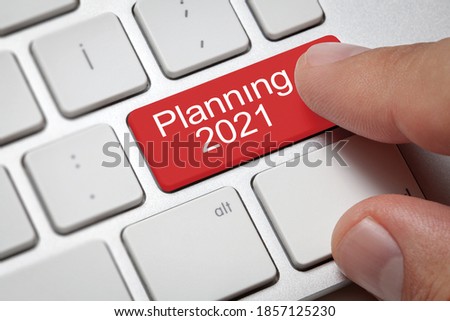 Business charts concept; Male hand pressing planning 2021 key on computer keyboard. Royalty-Free Stock Photo #1857125230