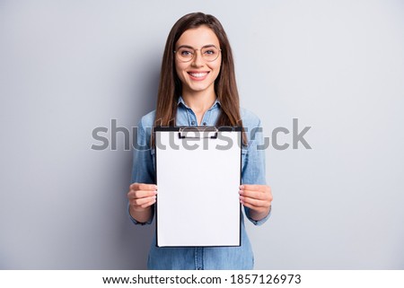 Photo of cheerful smart lady hands hold clip board showing list results isolated on grey color background Royalty-Free Stock Photo #1857126973