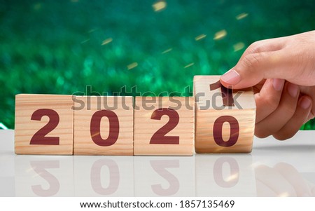 Hand changes the wooden cube from 2020 to 2021. Happy New Year 2021
