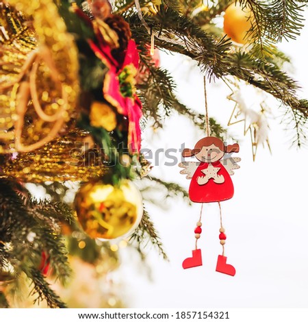 Outdoors image of beautiful decorated christmas tree on a town square. Christmas tree branches with balls, christmas tree toys, angel and festive lights with sparkles. Christmas decoration. New Year 