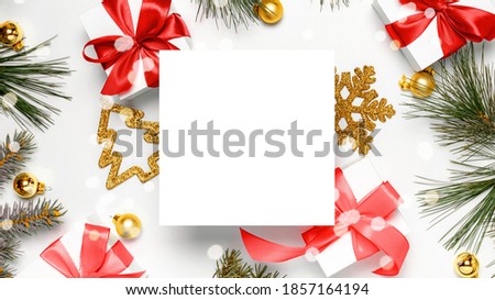 Christmas composition. White gift box with red ribbon, New Year balls and Christmas tree in xmas composition on white background for greeting card. Flat lay, top view, copy space.