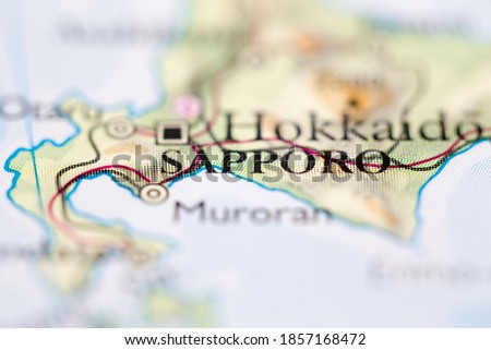 Shallow depth of field focus on geographical map location of Sapporo Japan Asia continent on atlas