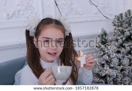 Beautiful girl of nine years old with long blond hair in a New Year's interior, a holiday Christmas