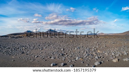 Panoramic view over Icelandic landscape of the deadliest volcanic desert in Highlands, with stones and rocks thrown by volcanic eruptions and hiking trek along the off road, Iceland, summer, blue sky Royalty-Free Stock Photo #1857195379