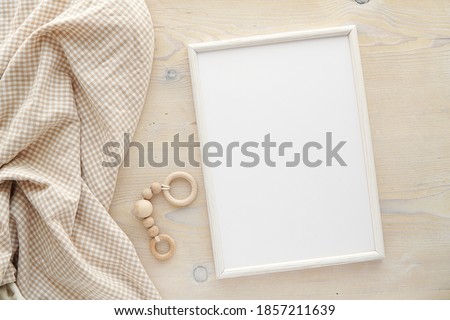 Nursery frame mockup, vertical white wooden frame mock up for baby room art, pregnancy announcement, top view, flat lay. Royalty-Free Stock Photo #1857211639