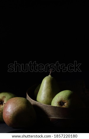 Pears isolated on black background, dark moody fruit composition in baroque artistic rembrandt lighting style, fine art design , vegan food and healthy organic food concept