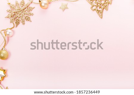 Christmas holiday composition. Festive creative gold pattern, xmas golden decor holiday ball with ribbon, snowflakes on pink background.
