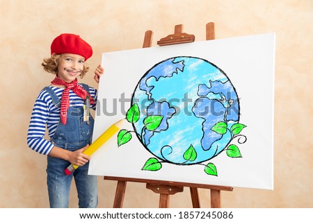 Artist child painting the picture on canvas. Happy kid pretend to be painter. Earth day concept