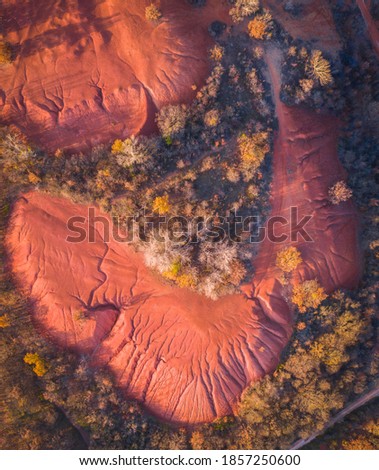 Gant, Hungary - Aerial view of abandoned bauxite mine, bauxite formation, the red mountains resembling Martian landscape. Red and orange colored surface, bauxite texture, warm autumn colors.