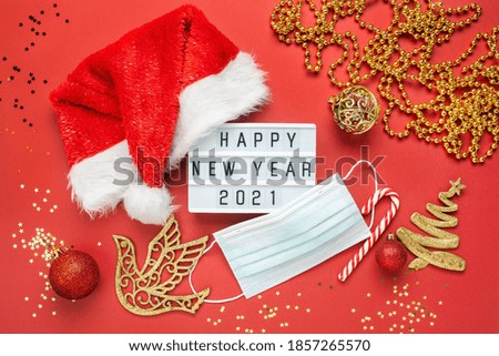 Christmas background, medical mask and lightbox with text Happy New Year 2021. Flat lay. Covid-19  concept.