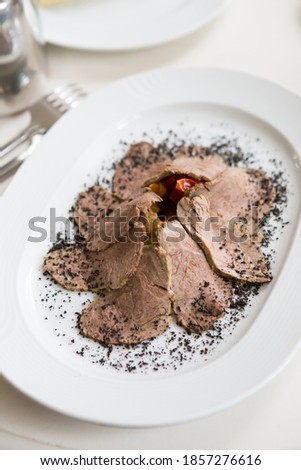 Sliced ham served with vegetables on a ple