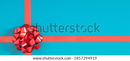 Red bow on blue background. Flat lay, top view, copy space, banner