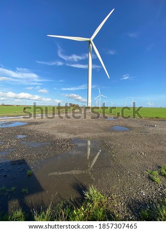 Wind farm turbines that produce electricity energy. Windmill Wind power technology productions Wind turbines standing in green field - stock footage
