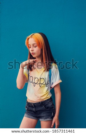 Girl portrait. A child outside in daylight during the day. Beautiful girl of school age with fashionable hair coloring. Positive portrait. A subtle girl with dyed bangs. Girl 9-11 years old