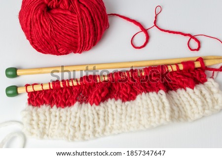 Close up of knitting stitches in Christmas colours on a needle