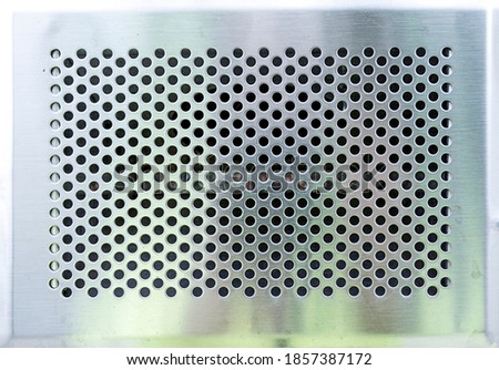 matte metal panel covered with holes to use as a background