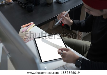 Cropped shot of male creative graphic designer is working on color swatches and drawing on graphics tablet at workplace with work tools and accessories.