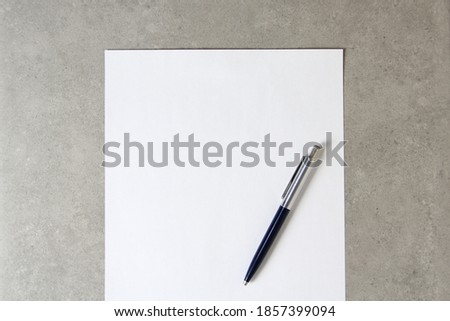 Template of white paper with a ballpoint pen on light grey concrete background. Concept of new idea, business plan and strategy, development and implementation of content. Stock photo with empty space