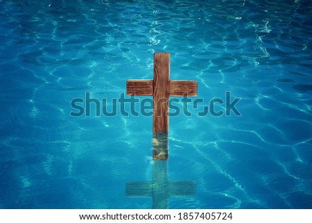 Wooden cross in water for religious ritual known as baptism Royalty-Free Stock Photo #1857405724