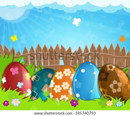 Colorful painted Easter eggs with abstract pattern near a wooden fence in the meadow