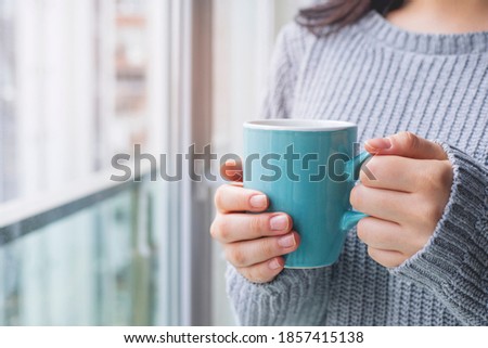Hand of woman holding a coffee cup