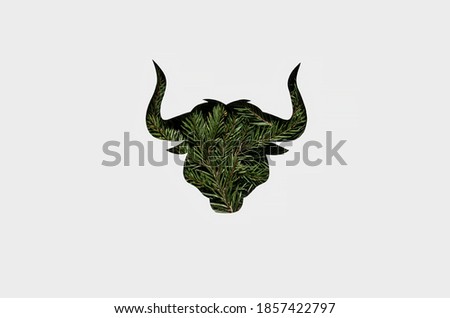 silhouette of a green bull with a Christmas trees on its body. New year 2021 card with the symbol of the year. Zero waste Christmas concept. Flat lay, top view. Flat lay, top view. paper cut bull