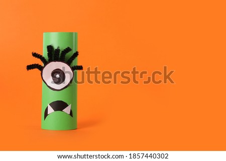 Funny green monster on orange background, space for text. Halloween decoration