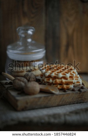 a delicious waffle walnut and a spoonful of honey are on the table