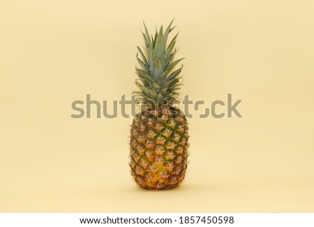 Ripe juicy ripe pineapple on a light yellow background. Minimalism. Tropical fruit
