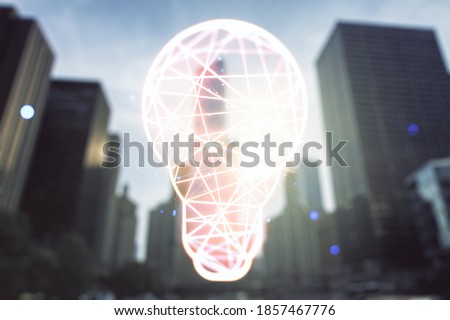 Abstract virtual light bulb hologram on blurry cityscape background, idea concept. Multiexposure
