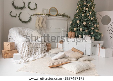 Christmas cozy place with a burning tree and white chair. Christmas holiday in the comfort of home