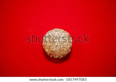 A Christmas golden ornament on a velvet red background