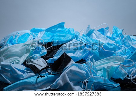 Medical masks on the table. Pile of used personal protective equipment PPE. Pollution by surgical masks during the coronavirus pandemic. A lot of Covid-19 plastic waste and garbage, disposable masks.  Royalty-Free Stock Photo #1857527383