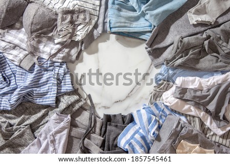 Frame made of clothing as pyjamas, undergarments, garments on a white marble background. Apparel sorting and decluttering. Concept of organic cotton clothing manufacturing. Nordic style. Copy space. Royalty-Free Stock Photo #1857545461