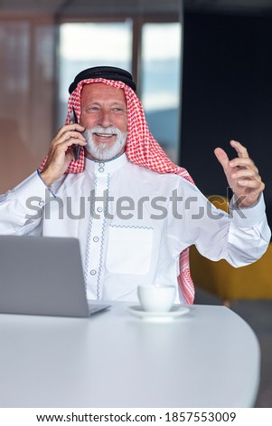 Arab businessman laptop computer in modern office using phone