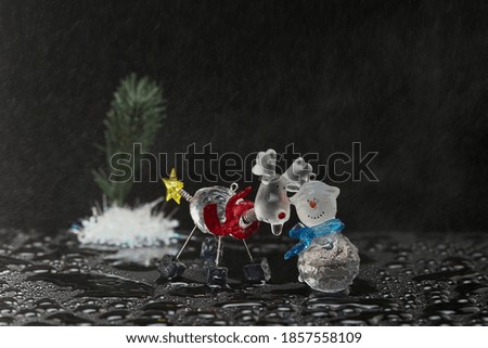 new year greeting card with a deer, snowman and snow on a dark background