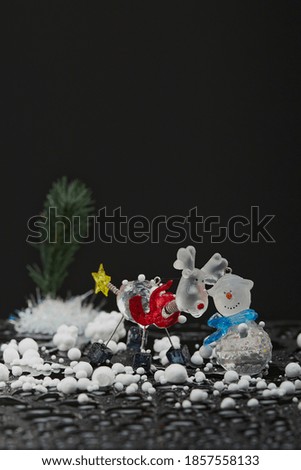 new year greeting card with a deer, snowman and snow on a dark background