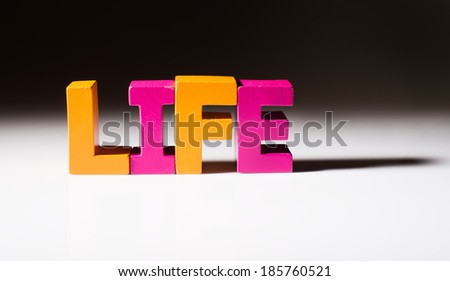 Multicolored text life made of wood. White background