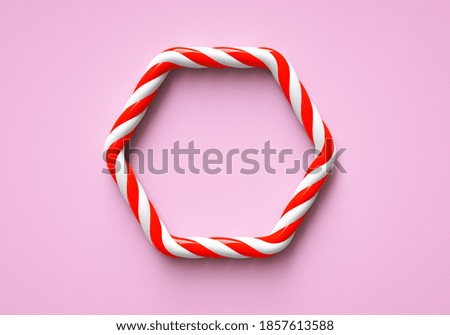 Classic red and white striped christmas candy color frame on pink background. Hexagon frame with copy space for candy bar. 3D rendering.