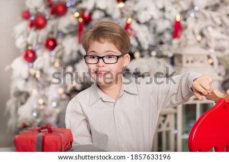 Emotional boy with down syndrome in Christmas decorations. Photo studio.