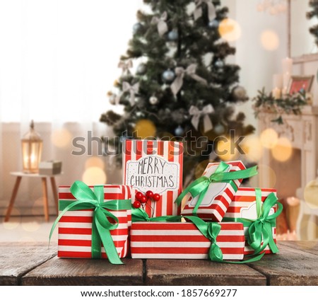 Christmas gift boxes on wooden table in room, bokeh effect