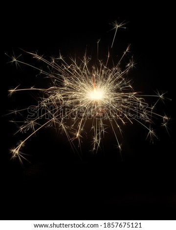 Glittering burning sparkler on black background