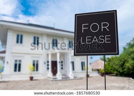 A Modern minimalist for lease sign in front of a beautiful new mansion or villa.