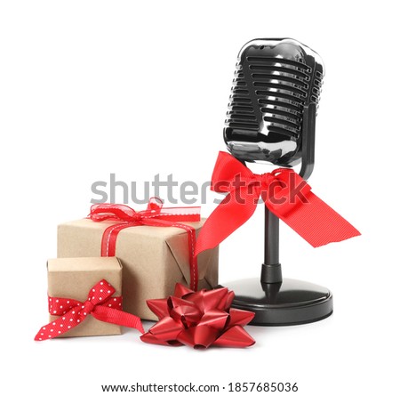 Retro microphone with red bow and gift boxes on white background. Christmas music
